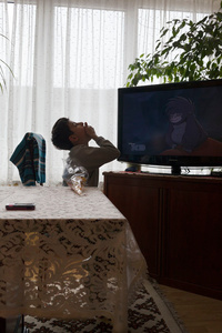 Alex eating sweet chips while watching Tarzan.