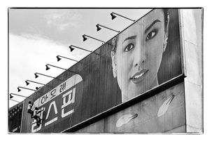 Men climbing on on large advertising panel, Seoul, South Korea