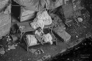 Dhobi sitting on a trestle table | Bombay, India.