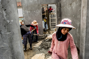 A team of cement mixers work on a house on the edge of Phnom Penh.