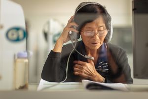 An elderly woman studies a foreign language in a language lab at a University of the Third Age (U3A). Older people can learn new languages and many other skills with state-of-the-art technology.