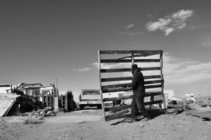 Dean carrying a pallet he'll chop into firewood. © Joseph Sorrentino