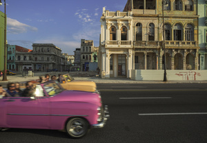 American vintage cars cruise down the Malecón, the seafront road in Havana.