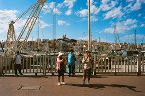 Tourist capturing a selfie with Notre-Dame de La Garde in the background.