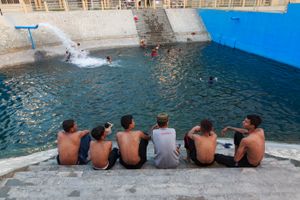 Some kids a rising and chatting on the pool stairs