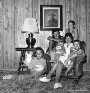 Downwinder Diane Nielson and her children, sitting beneath their prized painting of John Wayne. Henderson, Nevada, 1986