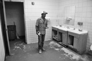 Workers begin getting up around midnight.  Here Juan waits to use the toilet. © Joseph Sorrentino