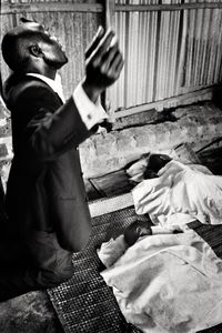 The picture was taken in a sacred place, during a healing ritual.The children on the floor had a high fever. Apart from some specific symbols, the Christian and Islamic religions often blend into each other, sometimes via shared pre-monotheistic traditions. In this specific image, the preacher is Christian, and the children are of a Muslim family. They recovered their health only a few days later.