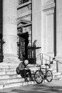 Cyclist sitting on the steps  of St Martins in the Fields