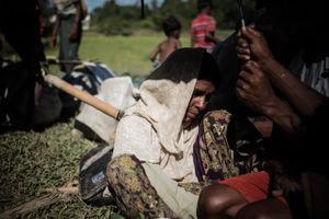 The Rohingya Refugee Crisis. A sick and totally exhausted refugee woman, waiting for food and water, in the burning sun in one of the camps, near Ukhia, Bangladesh.