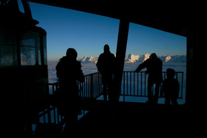 Skieurs en contre jour à la station de télécabine au sommet du Moléson, Gruyère.