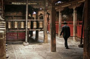 The Jokhang Temple is the most revered religious structure in Tibet. Parts of it were built as early as the 7th century. Prayer wheels line the outer kora or pilgrimage path. The wheels contain prayers that are chanted to gain merit and concentrate the mind. Photographed on 28 June 2005. © Forest McMullin