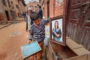 A boy salvaging belongings from a family home that was destroyed during the 2015 Nepal earthquake.