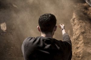 A mourner throws soli as others cover with soil the grave of a Kurdish fighter, killed in the fighting with the militants of the Islamic State group in Kobane, Syria, during a funeral of YPG fighter, at a cemetery in Suruc, on the Turkey-Syria border, November 06, 2014.