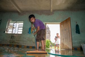 Edgardo Moo Kahuil helps his grandmother clean the house so they're ready to receive the deceased.
