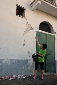 In the yellow area, Marianna shows the damages on the walls of her house. The building is not habitable anymore, because of the lots of cracks inside the house.