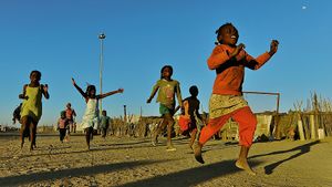 The slum of Modesa, near Swakopmund in Namibia. A group of girls run passing me by, as I lay on the ground to take a shot of them. They run joyfully expressing their zeal for life.