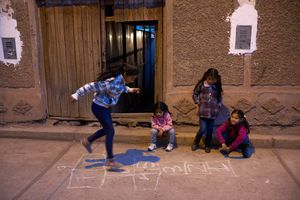 Girls playing hopscotch in the street, Calca, Peru