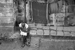 A dhobi sitting on steps | Bombay, India.