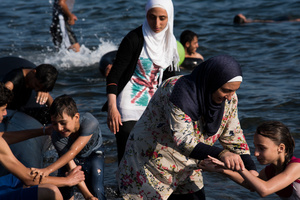 Syrian refugees make the victory sign after making the five mile crossing from Turkey to Greece.