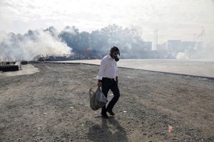A man with a gas mask walks past the flooded by tear gas Taksim square during clashes between protesters and riot police in Istanbul Tuesday on Tuesday, June 11, 2013.