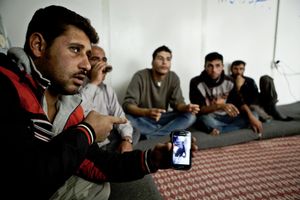 Former Free Syrian Army rebels showing footage of combat casualties on a smartphone. © Tom Verbruggen