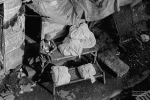 A  dhobi sitting on a trestle table | Bombay, India.
