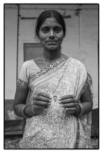 Rajitha with photo of her husband P. Ramesh, a debt-stressed farmer who committed suicide, Telengana , India.