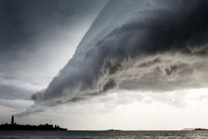 A storm cloud hangs above the San Servolo Island in central lagoon near the main island of Venice on September 26, 2012. Venice is subject to strong storms, Bora and scirocco winds that bring waves and high tides that eventually flood the city. Storms at sea and inland are especially dangerous. The open sea storms bring tides, while the inland storms bring flooding from rivers.