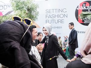 Model Lulu Elhasbu outside Jakarta Fashion Week's main venue, plays around with a paparazzo.