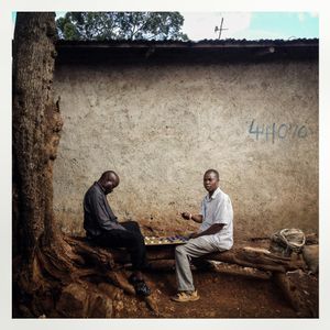 Men plays checkers in Kibera. The Kibera slum is the largest slum in Nairobi with around half a million inhabitants.