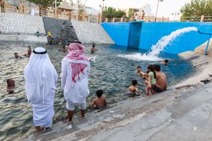 Some men which they don’t intend to swim but only want to feel the cool water by their feet in the pool