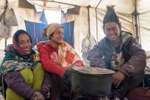 Teenagers warming themselves in a teahouse tent. Upper Dolpo, Nepal, June 2017.