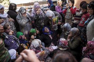 A woman cries as she holds a portrait of her son, a Kurdish People's Protection Unit (YPG) fighter who died during fighting in the besieged Syrian border town of Kobane, during his funeral in the town of Suruc, Sanliurfa province, Turkey on November 7, 2014.
