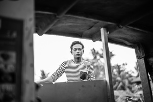 Young man make a living during the tourist season by steering the many boats that go to Siem Reap