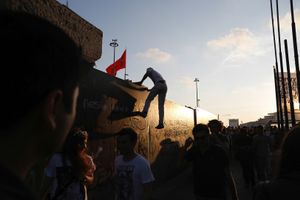 A protester tries to jump over the fence of the former Atatürk Cultural Center during a demonstration in Taksim square in Istanbul on Saturday, June 8 2013.