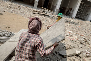 Two female workers carry a large section of wood across a building site in central Phnom Penh.