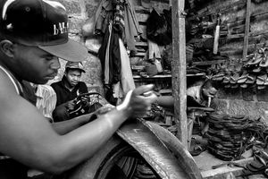 © Tony Corocher - The Production Process (Makadare Market/Slum) - Here we are inside Makadare, one of the largest markets/slums in Nairobi, where people work with old tires and rubber to produce shoes, tools and various other objects.