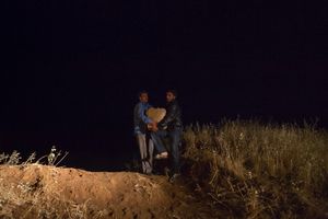 Two Syrian men, exhausted from their lengthy, tiring journey, are carrying a cardboard box of possessions the last few meters before they can rest. While the women are clinging to the children to keep everybody together, the men are carrying their earthly possessions. They have taken as much as they could possibly carry and anything that could be useful for their new life abroad. © David Brunetti