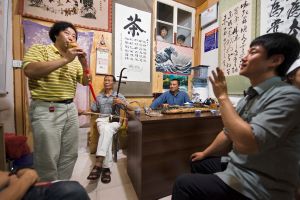 At a Weishan teashop,, a group of friends gather to listen to a duet on two traditional Chinese instruments: the flute-like hulusi and the two-stringed arhu. The large character in calligraphy on the wall is ‘tea’. © Michael Freeman