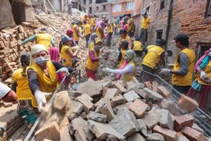 Volunteers with the World Mission Society help to clear rubble from buildings destroyed by the 2015 Nepal earthquake.