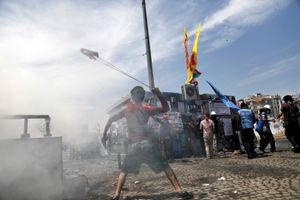 A protester uses a makeshift slingshot against riot police during clashes in Taksim square in Istanbul, Turkey on Tuesday, June 11, 2013.