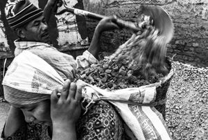 A woman carrying a basket of rocks and material for rebuilding homes destroyed by the earthquake.