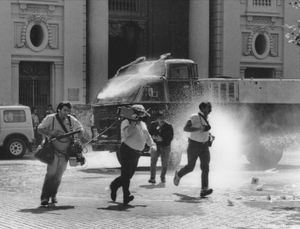 Journalists attacked by water-cannon during the 'NO' referendum campaign against Pinochet in 1988. Santiago, Chile,