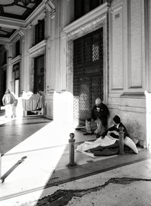Two homeless men sitting under a covered walkway. On the left you can see their 'home'; Naples 2017