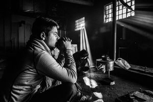 Refugees make tea on makeshift stove inside a derelict warehouse in Belgrade. Serbia.