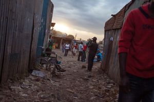 Sinai slum, Nairobi, KENYA, 29.10.2013: A boy in a wheelchair is begging in an alleyway of Sinai Slum. Sinai is part of the Mathare slum collection with an estimated population of 600.000. Many children who live here do not attend school to help their struggling parents make an additional income.