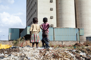 2013 Sinai Slum, Nairobi, KENYA.                    Children standing on a pile of garbage, looking over the walls that separate the slum from the city.