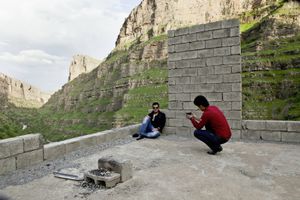 These two Kurdish tourists take photos and selfies in an abandoned construction site next to Hamilton Road near Khalifan. © Tom Verbruggen