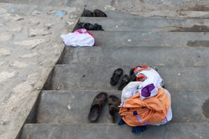 Clothes, sandals and towels on the stairs of the pool